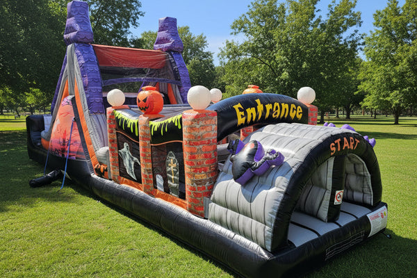 A Halloween-themed inflatable bounce house with a purple castle tower, orange pumpkin decorations, a gray slide section, and 'Entrance' and 'Stay' text, shown on a plain white background.